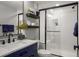 Updated bathroom with white subway tile shower, matte black hardware, and navy blue vanity with white countertop at 15960 W 62Nd Dr, Arvada, CO 80403
