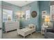 Well-lit Bedroom with a crib, changing table, comfortable chair, and neutral decor creating a soothing environment at 15960 W 62Nd Dr, Arvada, CO 80403