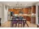 Eat-in kitchen featuring stainless steel appliances, wooden cabinets, and modern light fixtures at 15960 W 62Nd Dr, Arvada, CO 80403