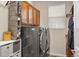 Functional laundry room with modern washer and dryer, storage cabinets, and ample shelving at 15960 W 62Nd Dr, Arvada, CO 80403