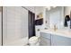 Bathroom with tub shower combination, gray vanity, and geometric tile floor at 1781 Chestnut Ave, Erie, CO 80516