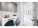 Laundry room with Whirlpool washer and dryer, gray cabinets, and ample storage at 1781 Chestnut Ave, Erie, CO 80516