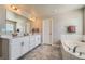 Bright bathroom with double sinks, a tub, and modern finishes at 9574 Keystone Trl, Parker, CO 80134