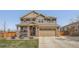 Charming two-story home with a manicured lawn, a covered porch, and an attached two-car garage at 9574 Keystone Trl, Parker, CO 80134