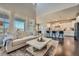 Open-concept living room with hardwood floors seamlessly connecting to a kitchen with counter seating at 9574 Keystone Trl, Parker, CO 80134