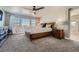 Spacious main bedroom with plush carpet, a ceiling fan, and a large window for natural light at 9574 Keystone Trl, Parker, CO 80134