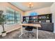 Well-lit home office featuring custom built-ins, plush carpeting, and large windows at 9574 Keystone Trl, Parker, CO 80134