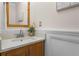 Bathroom vanity featuring framed mirror, wooden cabinets, and marble countertop at 10814 Bayfield Way, Parker, CO 80138