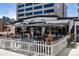 Charming outdoor patio with comfortable seating, white picket fence, and umbrellas at 3330 E 4Th Ave, Denver, CO 80206
