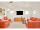 Bright living room with comfortable orange seating, modern furniture, and sleek entertainment center at 99 S Albion St, Denver, CO 80246