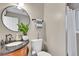 Elegant bathroom features a round mirror, a sleek vanity with granite countertop, and stylish fixtures at 5183 Durham Ct, Denver, CO 80239