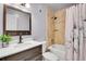 Well-lit bathroom featuring a vanity, granite countertop, framed mirror, and tiled shower with curtain at 5183 Durham Ct, Denver, CO 80239