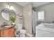 Well-lit bathroom with a modern sink, toilet, shower, and a washing machine for convenience at 5183 Durham Ct, Denver, CO 80239