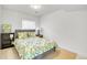 Serene bedroom featuring leafy bedding, light wood floors, ample natural light, and a small bookshelf at 5183 Durham Ct, Denver, CO 80239