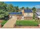 Inviting home featuring solar panels and a well-maintained front yard with a brick fence at 5183 Durham Ct, Denver, CO 80239