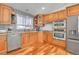 Updated kitchen with stainless steel appliances, granite countertops, herringbone backsplash, and wooden cabinets at 5183 Durham Ct, Denver, CO 80239