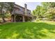 Expansive backyard with a stone patio, large deck, and mature trees, ideal for outdoor enjoyment at 9 Roder Gate Ln, Castle Pines, CO 80108