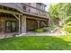 Inviting backyard space with a stone patio, lush green lawn, and a multi-level deck for entertaining at 9 Roder Gate Ln, Castle Pines, CO 80108