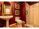 Elegant bathroom with a pedestal sink, toilet, and walk-in shower with white tiles and gold accents at 9 Roder Gate Ln, Castle Pines, CO 80108