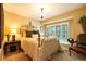 Cozy bedroom featuring a comfortable bed, chandelier, and window seat with plantation shutters at 9 Roder Gate Ln, Castle Pines, CO 80108