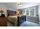 Cozy bedroom with a blue accent wall, classic furniture and a sunlit window with green views at 9 Roder Gate Ln, Castle Pines, CO 80108