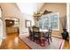 Elegant dining room with wood floors, bright windows, a stylish chandelier, and access to the kitchen at 9 Roder Gate Ln, Castle Pines, CO 80108