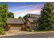 Beautiful home exterior with stone accents, a manicured lawn, and mature trees, creating inviting curb appeal at 9 Roder Gate Ln, Castle Pines, CO 80108