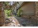 Stone pathway alongside the house, showcasing natural landscaping and access to outdoor spaces at 9 Roder Gate Ln, Castle Pines, CO 80108
