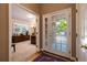Welcoming foyer featuring hardwood floors, a bright glass door, and an open view into a carpeted office space at 9 Roder Gate Ln, Castle Pines, CO 80108
