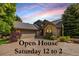 Charming home exterior featuring stone accents, a well-maintained lawn, and a two-car garage, with open house signage at 9 Roder Gate Ln, Castle Pines, CO 80108