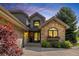 Attractive home with stone and siding exterior, showcasing arched windows, mature trees and a covered entry at 9 Roder Gate Ln, Castle Pines, CO 80108