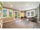 Sunlit living room with large windows, glass doors leading to the backyard and stylish patterned chairs at 9 Roder Gate Ln, Castle Pines, CO 80108