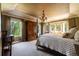 Luxurious main bedroom with a large bed, chandelier, wood armoire, and abundant natural light from several windows at 9 Roder Gate Ln, Castle Pines, CO 80108