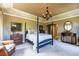 Spacious main bedroom featuring a bed, chandelier, dresser, chair, and arched doorway leading to an en-suite bathroom at 9 Roder Gate Ln, Castle Pines, CO 80108