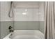Clean bathroom tub with grey tiling and silver shower head and fixtures at 1355 Gaylord St # 6, Denver, CO 80206