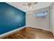 Cozy bedroom featuring dark blue accent wall, hardwood floors, ceiling fan and natural light at 1355 Gaylord St # 6, Denver, CO 80206