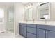 Bright bathroom featuring a double sink vanity with modern fixtures and a glass-enclosed shower at 22921 E Union Ave, Aurora, CO 80015