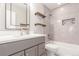 Updated bathroom with modern vanity, wooden shelving and decorative tile in the bath and shower at 22921 E Union Ave, Aurora, CO 80015