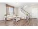 Bright living room features hardwood floors, a plush sofa and staircase leading to the upper level at 22921 E Union Ave, Aurora, CO 80015