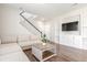 Comfortable living room with a neutral sofa, built-in shelving, and staircase at 22921 E Union Ave, Aurora, CO 80015