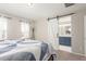 Main bedroom with sliding barn door to bathroom, plush carpet, and natural light at 22921 E Union Ave, Aurora, CO 80015