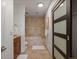 Bright bathroom with travertine tile, a tub and glass enclosed shower at 975 N Lincoln St # 3H, Denver, CO 80203