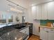 Modern kitchen featuring granite countertops, white cabinets, and stylish pendant lighting at 975 N Lincoln St # 3H, Denver, CO 80203