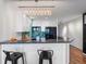 Bright kitchen boasts white cabinets, black appliances, a breakfast bar, and a stylish crystal chandelier at 975 N Lincoln St # 3H, Denver, CO 80203