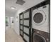 Convenient laundry area with stacked washer and dryer and sliding door access at 975 N Lincoln St # 3H, Denver, CO 80203