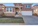 Charming two-story home features a stone facade and a well-manicured lawn, enhancing its curb appeal at 10778 Mountshire Cir, Highlands Ranch, CO 80126