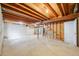 Unfinished basement space with exposed wood beams, concrete floor, and concrete walls at 12717 E Cornell Ave, Aurora, CO 80014