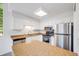 Well-lit kitchen includes stainless steel appliances, wood floors and an island for added space at 12717 E Cornell Ave, Aurora, CO 80014
