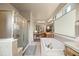 Large bathroom with tiled soaking tub, glass shower, double vanity, and private commode at 11961 S Saunter Ln, Parker, CO 80138