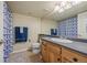 Bright bathroom features wood vanity with gray countertop, large mirror, and blue patterned shower curtain at 11961 S Saunter Ln, Parker, CO 80138